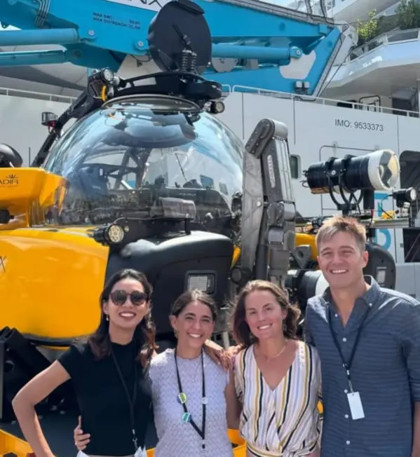 REEF Scuba team members in front of a research submersible at an ocean conference.