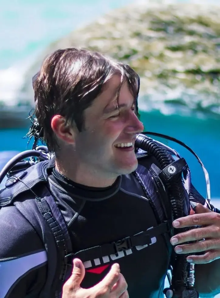 Graham Patterson, co-founder of REEF Scuba, in scuba gear near the water.